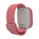 Baksida av rosa Xplora X6Play med synlig laddkontakt och mjukt flätat armband. Den barnvänliga designen inkluderar snabbkopplingar för enkel användning och justering.
