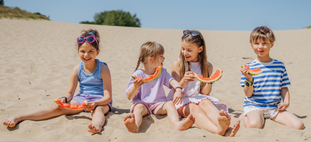 Barn på strand äter vattenmelon – smartklocka för barn Xplora